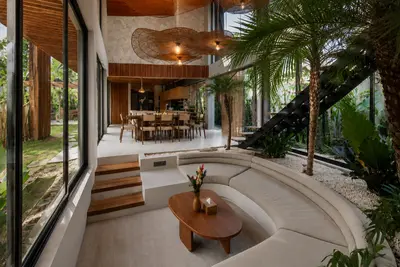 The sunken lounge and timber lined living space at Villa Livare, planting behind the glazing