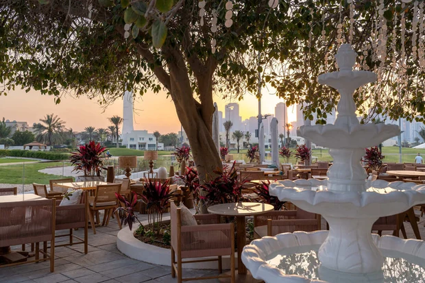 The Brunch and Cake terrace in Dubai, cane chairs and marble tables around a stone fountain