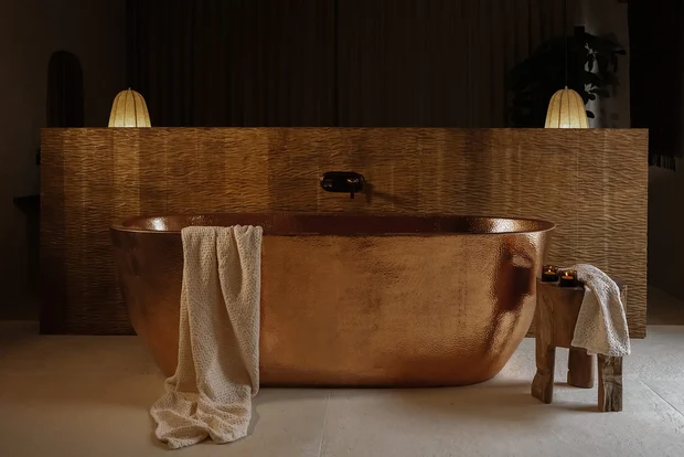 Copper bath against a woven panel wall at Mana Sanctuary