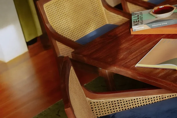 Cane and timber dining chairs around a polished table at Rumah Buaya