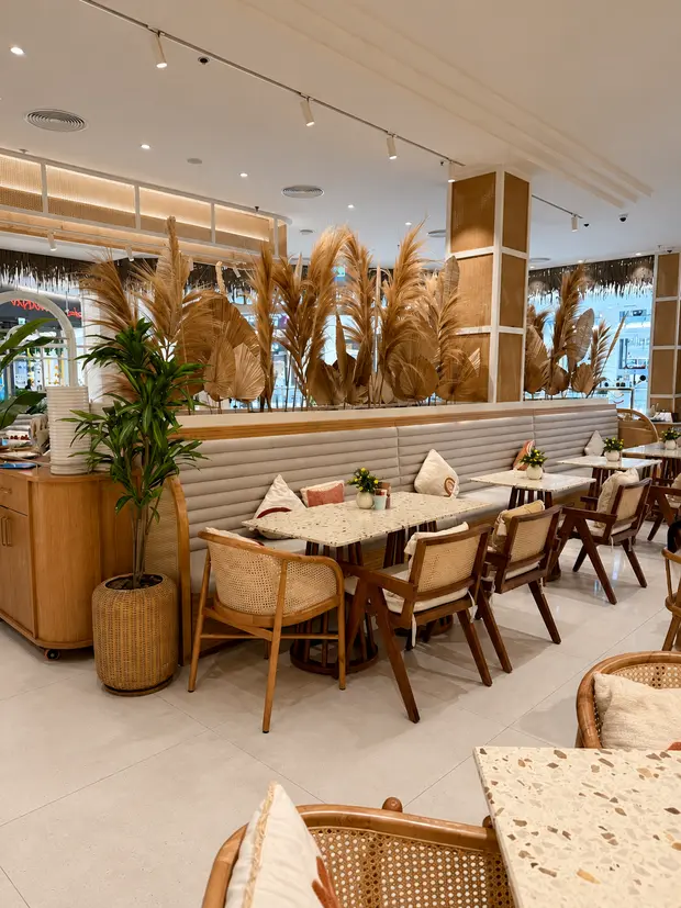 Rattan chairs and stone topped tables among dried grasses at City Centre Bahrain