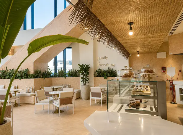 A woven cane ceiling above pale timber chairs and the counter at Olas